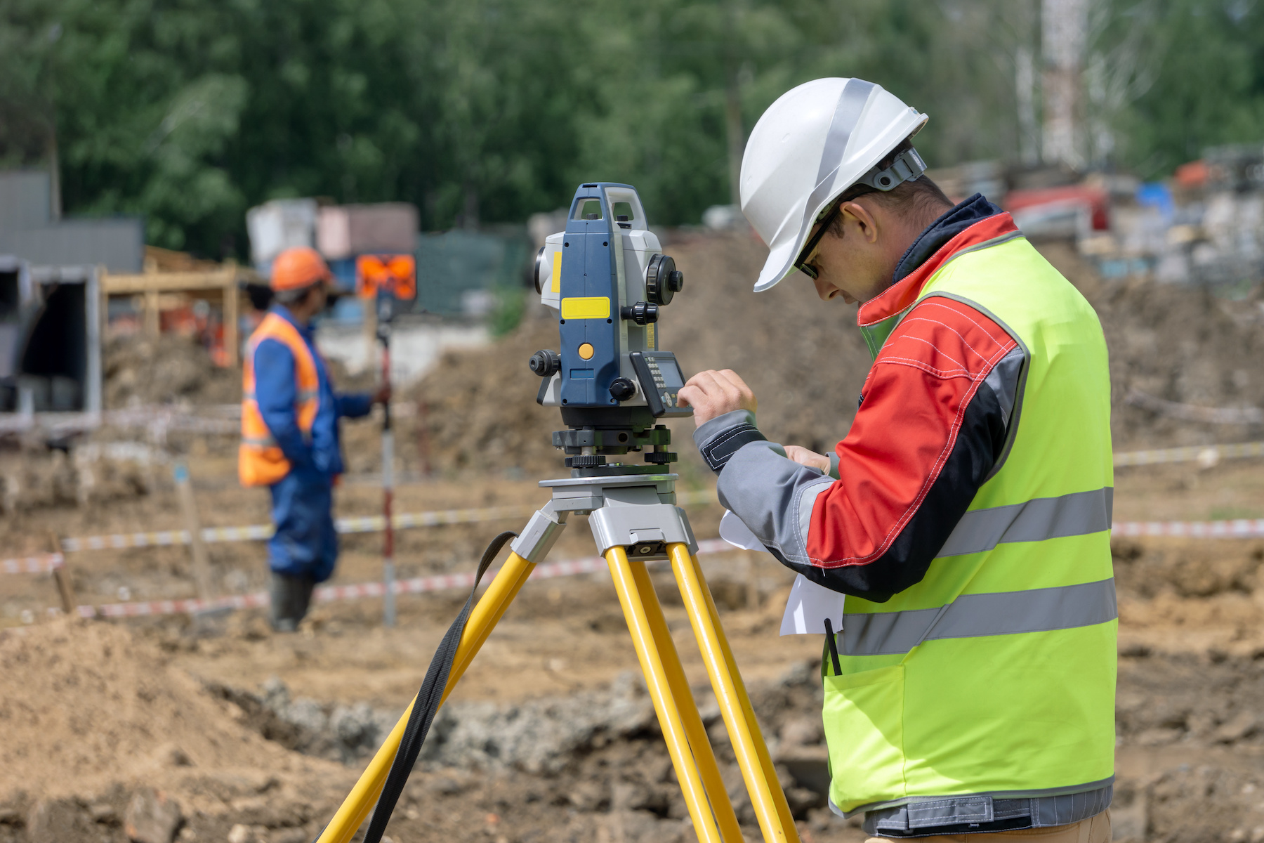 Surveyor making measurements and entering data