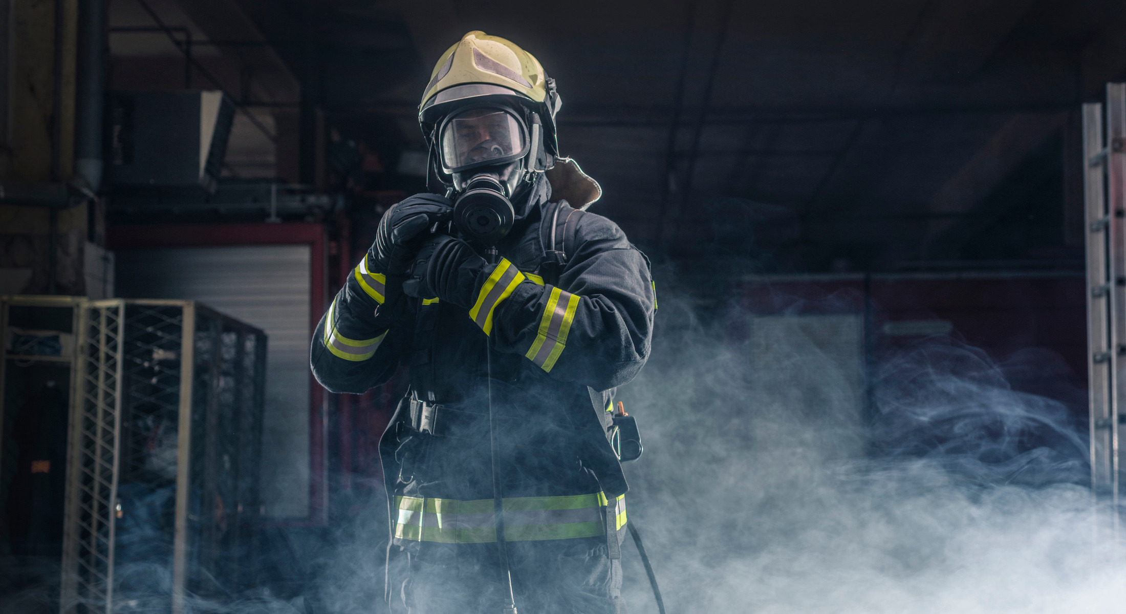 A firefighter in a smoke filled warehouse