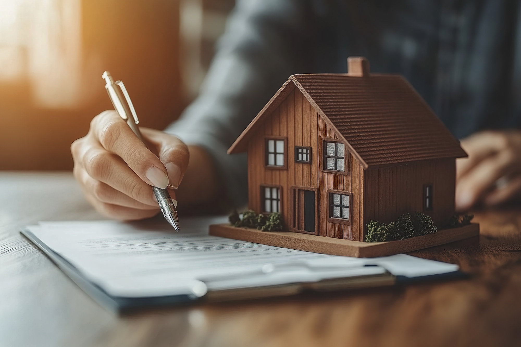 Miniature house next to documents